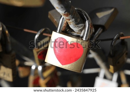 locks with red heart sign sticker hanging on bridge fence. forever Love.  Lock sign with heart shape. simple lock. Shape of a heart. Red icon at golden sticker on river background.