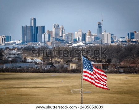 Picture of an American flag with Detroit skyline in the background