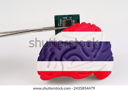 On a white background, a model of the brain with a picture of a flag - Thailand, a microcircuit, a processor, is implanted into it. Close-up