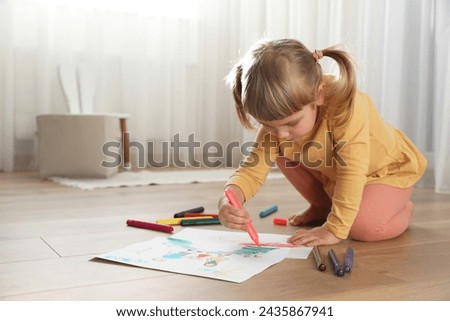 Cute little girl drawing with marker on floor indoors. Child`s art