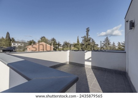 A large empty terrace in the attic of a residential house in an urbanization with several corners and views of a wooded area Royalty-Free Stock Photo #2435879565