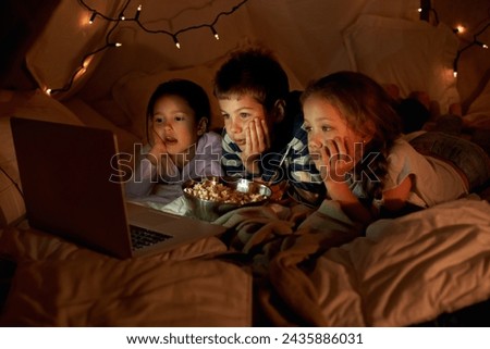 Children, laptop and watch in tent at night with movies, film or cartoons for holiday adventure or vacation. Young boy, girl or kids with lights, pillows and blanket at home on computer for Netflix