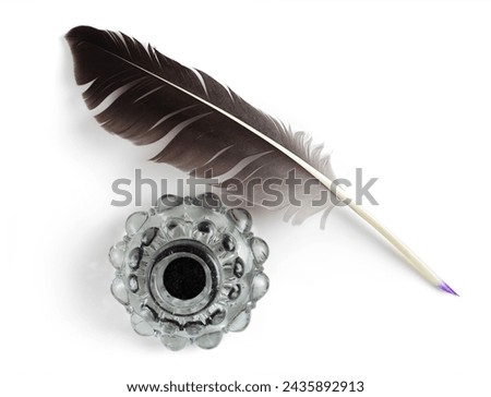 Feather with a vintage glass bottle of ink. Feather for calligraphy, old education, vintage fonts. Top view. Royalty-Free Stock Photo #2435892913