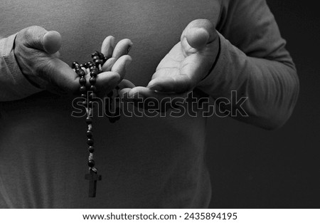 man praying to god with hands together on dark background with people stock image stock photo