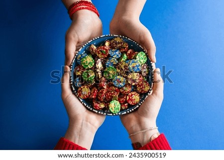 Top View Image of Woman Hand Holding Bowl of Candies. Ramadan Feast Celebration Concept, Colorful Candy and Chocolate Photo, Uskudar Istanbul, Turkiye (Turkey) Royalty-Free Stock Photo #2435900519