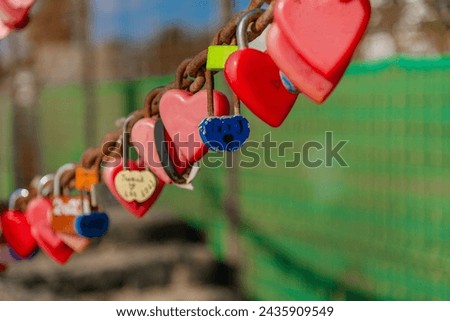 Red heart shaped locks on a large rusty chain