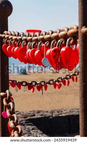 Red padlocks locked onto a large rusty chain symbolizing love and devotion amongst couples