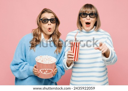 Elder parent mom young adult daughter two women wear blue casual clothes 3d glasses watch movie film hold bucket of popcorn cup of soda pop in cinema laugh isolated on yellow background Family concept