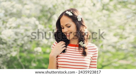 Portrait of lovely happy smiling young woman in spring blooming garden with white flowers on the trees in park Royalty-Free Stock Photo #2435923817