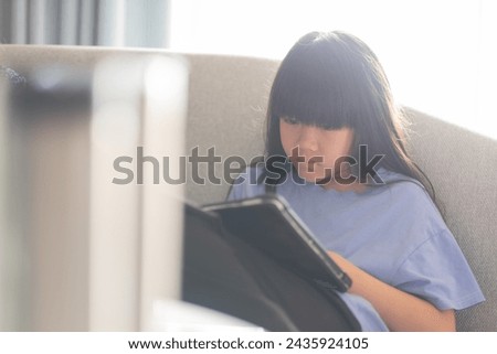 kid is addicted to tablet, little girl playing smartphone, kid use telephone, watching cartoon

