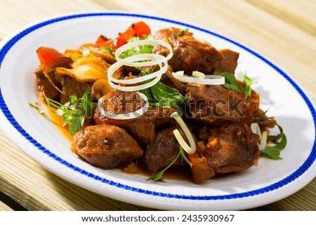 Cooked fried pork meat with peppers, mushrooms and onion served on plate