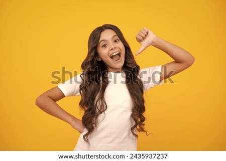 Close-up portrait of her she nice cute attractive cheerful amazed girl pointing aside on copy space isolated on yellow background. Amazed teen girl. Excited expression, cheerful and glad.