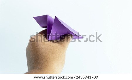 Purple paper airplane held in hand isolated on white background
