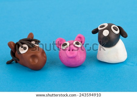 Cute plasticine farm animals collection isolated on blue background. Pig, horse, sheep.