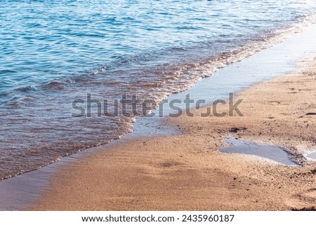 Soft wave of the sea on the sandy beach. Sea wave and gold sand.