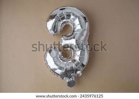 3 three metallic balloon on beige neutral background. Greeting card silver foil balloon number Happy birthday holiday concept. Copy space for text. Celebration party congratulation