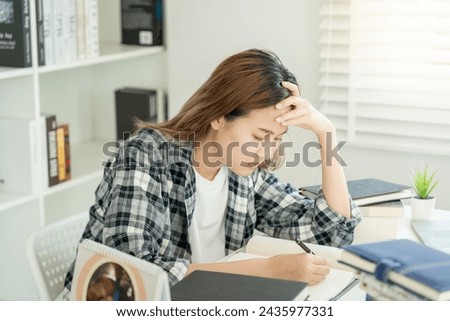 Asian student woman have anxiety because of exams, female prepare for test and learning lessons in the library. stress, despair, haste, misunderstanding reading, discouraged, expectation, knowledge
