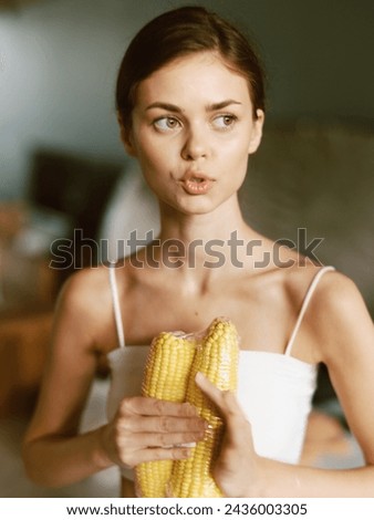 Smiling Woman Enjoying a Healthy Corn Salad in her Sunlit Home Kitchen A young woman is pictured in her cozy kitchen, holding a plate filled with a colorful corn salad The image radiates a sense of