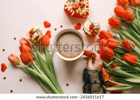 Cup of coffee, bouquet of red tulips and cake top view flat lay, festive background.