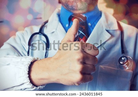 Medicine, profession and healthcare concept - male doctor in white coat with stethoscope showing thumbs up with flare effect
