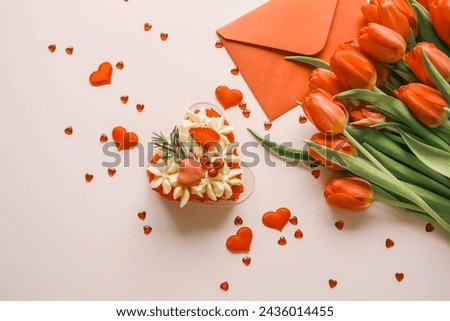 Birthday cake, bouquet of red tulips and envelope with letter, holiday gift.