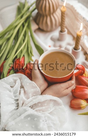 A cup of coffee in the hands of a girl, good spring morning.