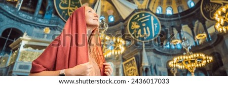 BANNER, LONG FORMAT denoting the names of Allah, the Prophet Muhammad, as well as the first 4 caliphs Woman tourist enjoying Hagia Sofia, Ayasofya interior in Istanbul, Turkey, Byzantine architecture