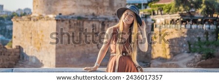 Woman tourist on background of Hidirlik Tower in Antalya against the backdrop of the Mediterranean bay of the ancient Kaleici district, Turkey. Turkiye BANNER, LONG FORMAT