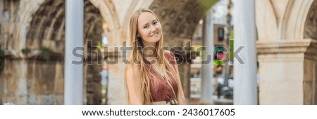 BANNER, LONG FORMAT Happy female tourist traveler discover interesting places and popular attractions and walks in the old city of Antalya. Hadrian Kapisi turkey landmark city history. Popular tourist