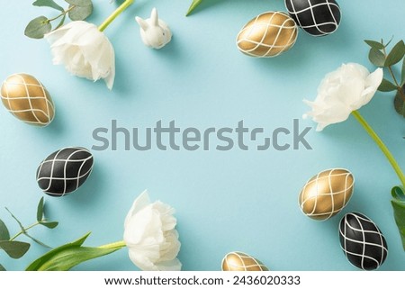 Premium Easter concept in a top-view photo. Showcases rich black and gold eggs, charming bunny figure, eucalyptus leaves, and tulips, arranged neatly on soft blue surface, with blank area for wording