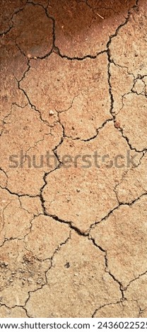 The image captures the desolation of cracked earth, stretching endlessly under the scorching sun. Deep crevices zigzag across the parched landscape. Royalty-Free Stock Photo #2436022525