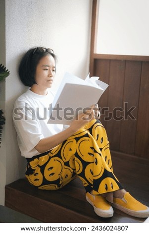 woman holding and opening a book or mock-up magazine at home.