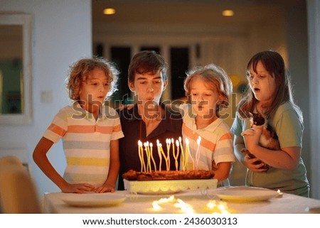 Teenager boy birthday with family and younger brother and sister. Siblings blow candles at party cake. Family love. Kids hug and kiss big brother. Children bonding.