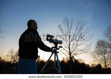 Amateur astronomer observing Sun eclipse and Sun with a telescope and special solar filter. Royalty-Free Stock Photo #2436031335