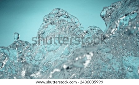 Freeze Motion of Water Splash in Closeup. Isolated on Blue Background.