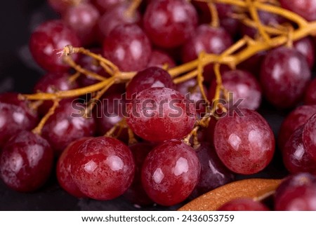 large red wet grapes in drops of water, details of red grapes