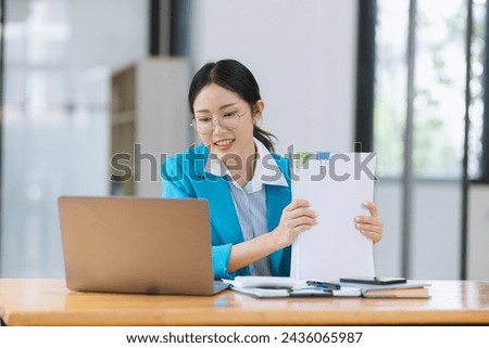 Asian accounting woman working with document paper and laptop computer at table office, Financial and accounting woman concept. 