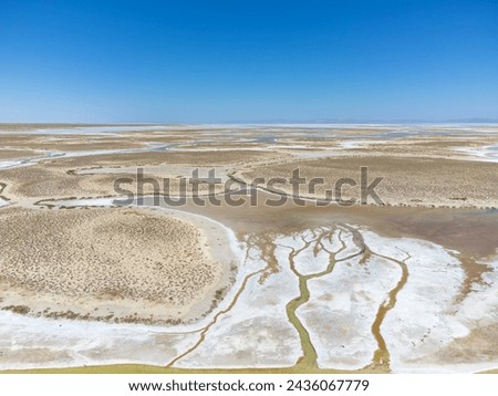 Drone view of dead salt lake Tuz in Turkey. Landscape is like on Moon or Mars, everything dried covered with salt. Here, edible salt is extracted and processed in factory or factory. Alien landscape. Royalty-Free Stock Photo #2436067779