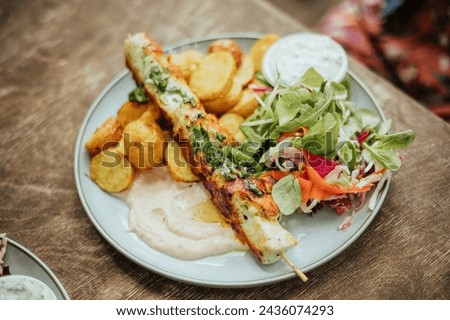 grilled chicken skewer with roasted potatoes on wood table summer cafe