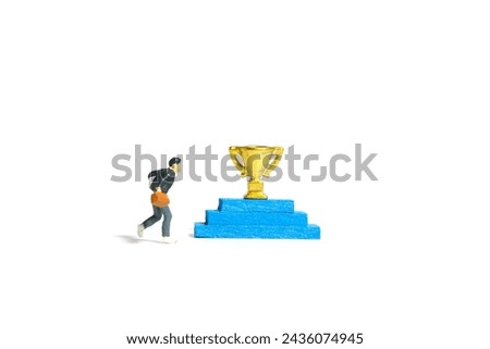 Miniature people toy figure photography. A boy pupil student running toward podium with trophy. Isolated on a white background. Image photo