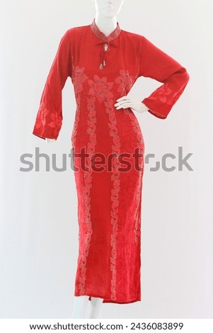Red long dress with long sleeves, have a feminine pattern made from soft and cool satin. Royalty-Free Stock Photo #2436083899