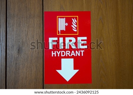 Red sticker with fire extinguisher sign on wooden wall