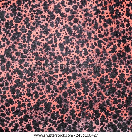 Detailed close-up capturing the intricate beauty of a leopard print alike texture on a old paper print. Vibrant interplay of black spots against a rich, coral background.