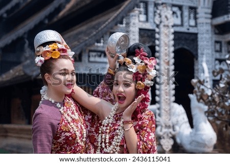 Portrait young Asia woman and girl in Thai Traditional Dress holding silver bowl to celebrate Songkarn festival, Culture lifestyle of people on Thailand New Year. Playing with water splashing Songkran