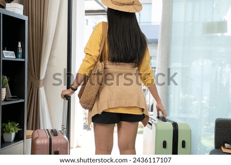 Young Asian woman with suitcase at vacation time.