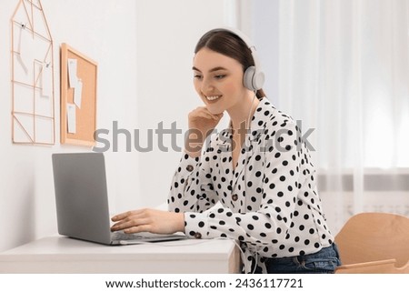 E-learning. Young woman using laptop during online lesson at table indoors