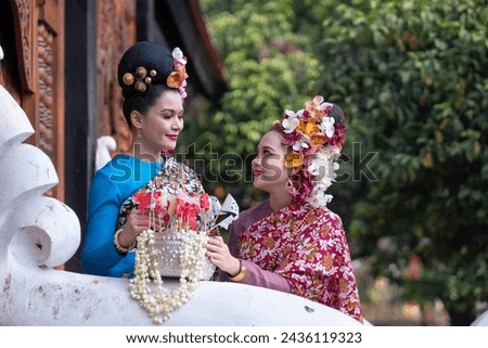 Portrait young Asia women in Thai Traditional Dress holding silver bowl to celebrate Songkarn festival, Culture lifestyle of people on Thailand New Year. Playing with water splashing during day