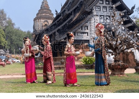 Portrait young Asia woman and girl in Thai Traditional Dress holding silver bowl to celebrate Songkarn festival, Culture lifestyle of people on Thailand New Year. Playing with water splashing Songkarn
