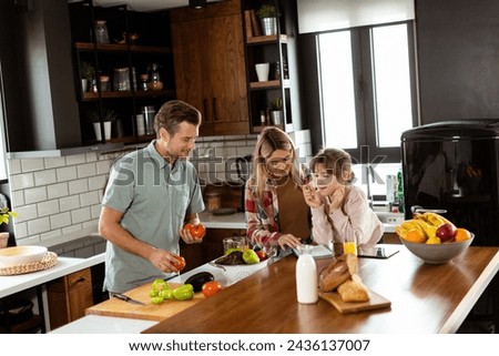 Young family chatting and preparing food around a bustling kitchen counter filled with fresh ingredients and cooking utensils