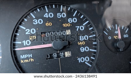 A vehicle analog odometer showing 100,000 miles driven. Royalty-Free Stock Photo #2436138491